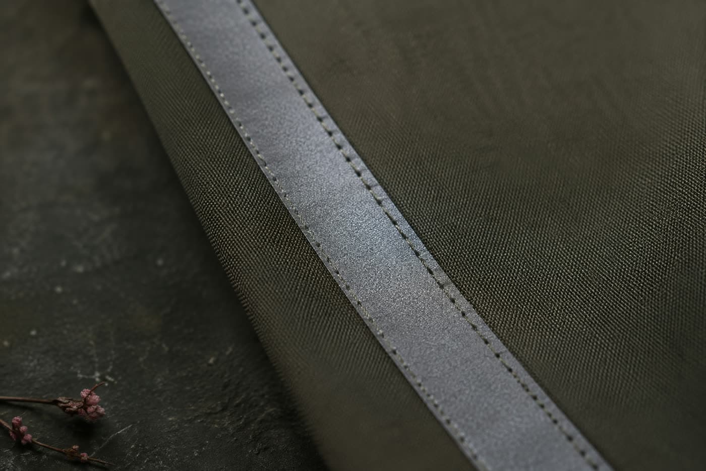 Close detail of reflective tape stitched onto a garment panel